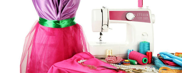 Sewing machine and cloth on a pink background. Sew clothes on a sewing  machine from knitting fabric. Fabric, measuring tape, thread, scissors and  sewing machine on a pink background. Stock Photo